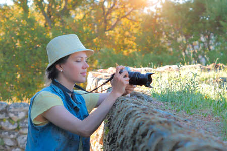 Female photographer taking photo in beautiful countryside.の写真素材