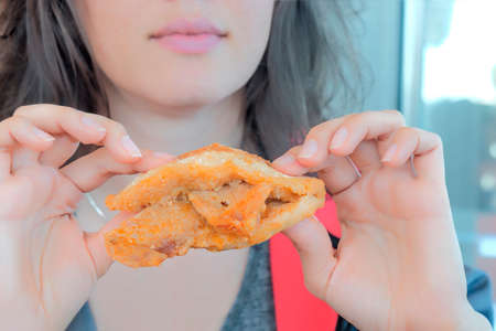 Woman holding in hands meat sandwich and going to eat it.の写真素材