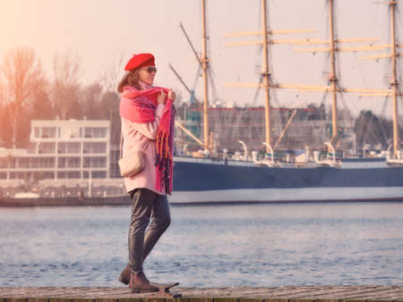 Beautiful young caucasian woman in a plaid walking on a wooden bridge, lifestyle portrait in nature.の写真素材