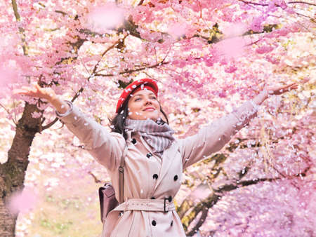 Beautiful woman enjoying a flowering spring gardenの写真素材