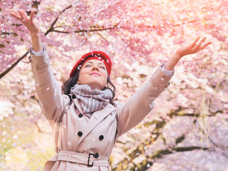 Woman throwing flower petals enjoying spring gardenの写真素材
