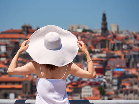 Woman tourist with travel bag enjoying cityscape of Porto, Portugalの写真素材
