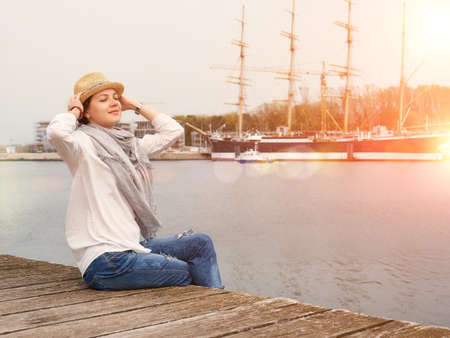 Woman in seaport relaxing with yachts on background.