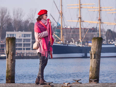 Beautiful woman in a plaid walking on a wooden bridgeの写真素材