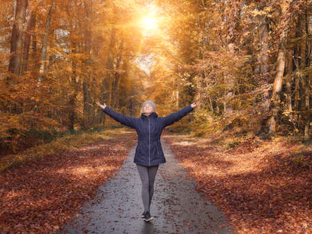 Freedom ideas concept, woman with raised hands up in forestの写真素材