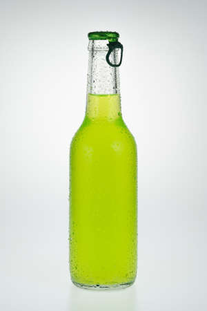 A capped glass bottle with green emerald cocktail liquid in it の写真素材