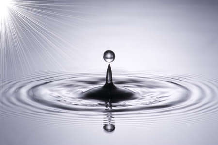 A small water drop fall on water surface and the splash jump to form a good clear, beautiful shape 