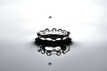 A small water drop fall on water surface and make a crown-shaped ripple の写真素材