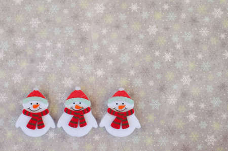 Winter background with a trio of snowmenの写真素材