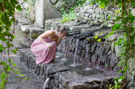 Tourist drinking water of Chorros de Epina, La Gomera, Canary Islands, Spain.