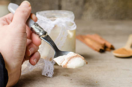Eating a spoonful of yogurt cinnamon, rustic background.の写真素材