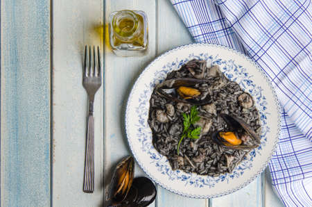 Black rice with squid, squid ink, prawns, cockles and olive oil.の写真素材