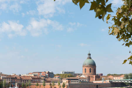The Saint Pierre bridge passes over the Garonne river and Hospital de La Grave in Toulouse, the French pink city.の写真素材