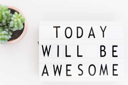 'Today will be awesome' words on a lightbox over white background, overhead view. Flat lay, from...