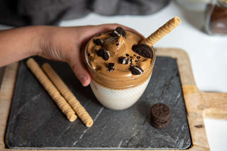 Glass with Dalgona frothy coffee trend korean drink latte espresso with coffee foamの写真素材