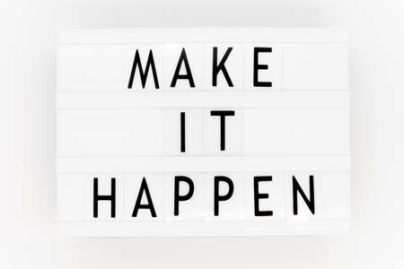 'Make it happen' words on a lightbox, top view. Overhead, from above, flat lay.の写真素材