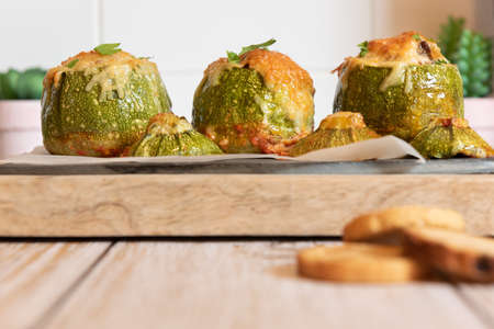 Stuffed zucchini. Round zucchini stuffed with meat and vegetables. Cheese on topの写真素材