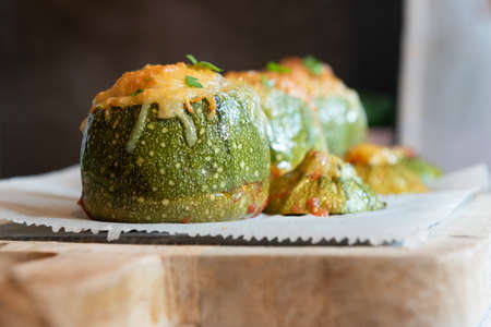 Stuffed zucchini. Round zucchini stuffed with meat and vegetables. Cheese on topの写真素材