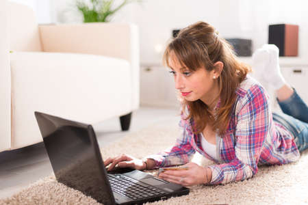 Cheerful young women at home, preparing at tripand buying on internetの写真素材