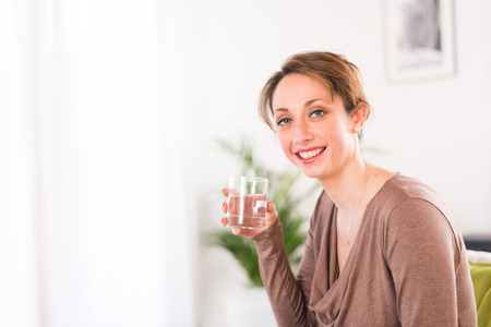 cheerful young women drinking mineral waterの写真素材