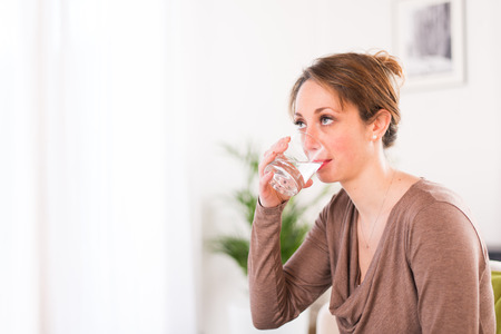 cheerful young women drinking mineral waterの写真素材