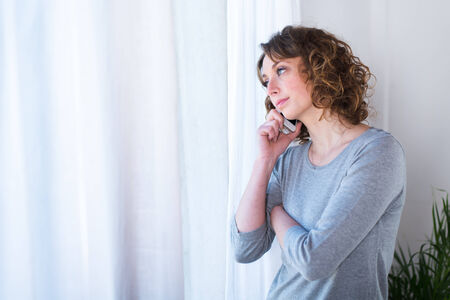 isolated portrait of a beautiful young woman  having telephone conversationの写真素材