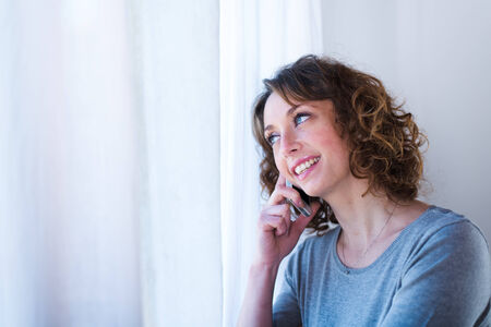 isolated portrait of a beautiful young woman  having telephone conversationの写真素材
