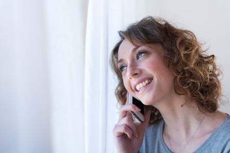isolated portrait of a beautiful young woman  having telephone conversationの写真素材