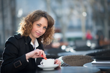 portrait of a beautiful young woman having tea in a cafÃ© terraceの写真素材