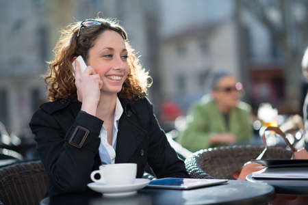 portrait of a beautiful young woman having tea in a cafÃ© terraceの写真素材