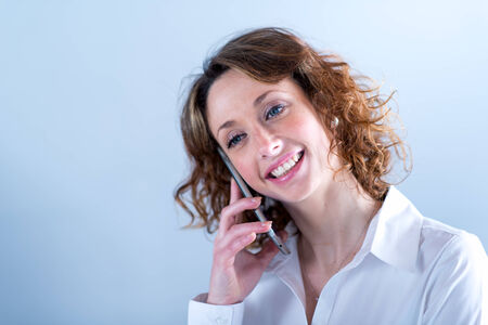 isolated portrait of a beautiful young woman  having telephone conversationの写真素材