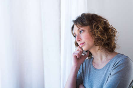 isolated portrait of a beautiful young woman  having telephone conversationの写真素材