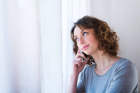 isolated portrait of a beautiful young woman  having telephone conversationの写真素材