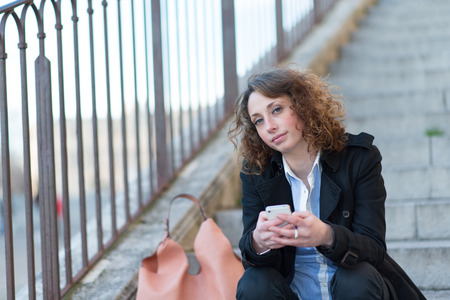 beautiful young woman siting in a staircase outisdeの写真素材