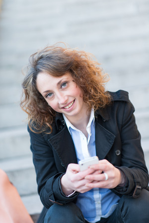 beautiful young woman siting in a staircase outisdeの写真素材