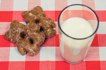 Close up photo of cookies and glass og milk on checkered tableclothの写真素材
