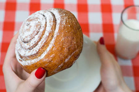 Person is going to bite tasty sweety cinnamon rollの写真素材