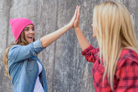 Team celebrate work kids give slap clap bonding brunette blonde hairstyle concept. Portrait of cute funky funny sweet lovely beautiful pretty glad nice with toothy smile lady isolated gray backgroundの写真素材