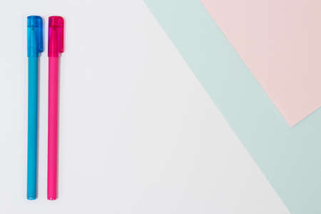 Concept of thinking. Top view photo of two bright pens on white, blue and pink background. Minimal styleの写真素材