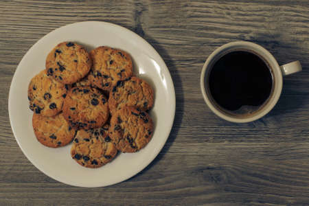 Top above overhead close up view photo of tasty yummy homemade biscuit with chocolate on white eroud plate dark morning coffee isolated on wooden background copy-space. Tasty breakfast.の写真素材