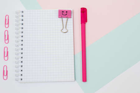 Top view photo of school supplies. Set of open empty spiral notebook, pen and paper clips. Girlish, minimal style. Pink colorsの写真素材