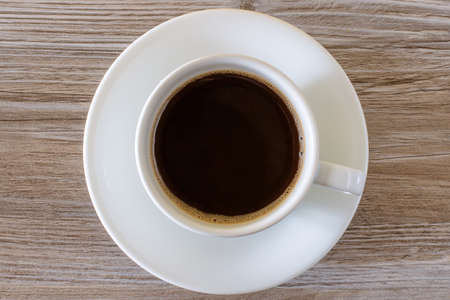 Top up overhead close up view photo of a cup of tasty with a foam dark fresh morning isolated on a white background. Wallpaper, snack beverage.の写真素材