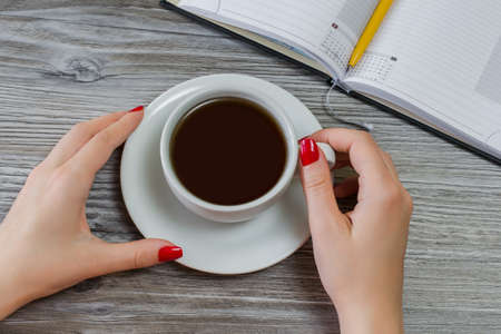 Woman is drinking tea while having time off from writing and studyingの写真素材