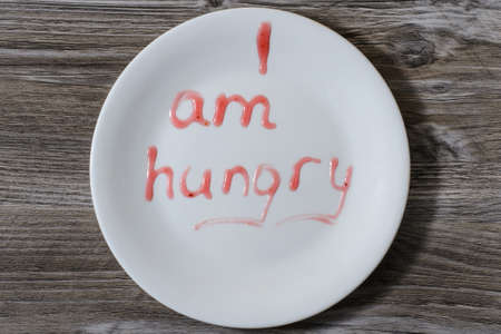 A plate with inscription I am hungry on it written with red berry sauceの写真素材