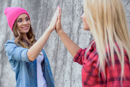 Party person people teen age best trend style wall win swag sign play touch concept. Close up portrait of charming lovely sweet cute pretty lady giving high five to friend isolated on gray backgroundの写真素材