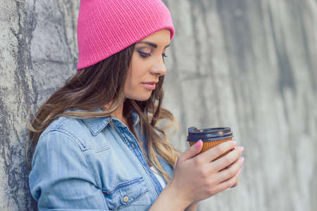Nails headwear shop wait comfort peace people person concept. Side close up view portrait of lovely calm beautiful pretty attractive cheerful lady holding warm mug tea in hands casual outfit clothesの写真素材