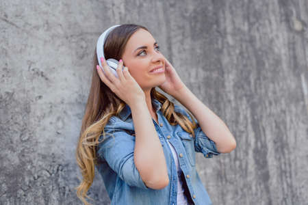Side profile close up view portrait of  attractive beautiful cute lovely pretty cheerful excited joyful delightful rejoicing lady listening to favorite track tune isolated on gray concrete backgroundの写真素材