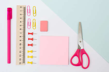 Overhead view photo of school supplies. Set of  scissors, stickers, rubber, ruler, paper clips and pins, pen on white backgroundの写真素材