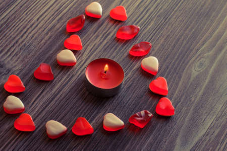 Jelly candies in shape of heart with candle flame の写真素材