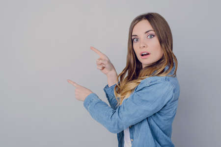 Wondered girl showing empty space isolated gray background